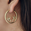 A vintage hoop earring with diamond cut love birds carrying a heart in the middle of the hoop. This hoop has very thick tubing and secure closure. 