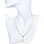 Pearl necklace with heart-shaped pink gemstones on a mannequin bust.