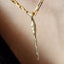 Gold necklace with a unique pendant on a blurred background