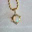 Gold necklace with an opal pendant on a textured white background