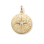 A round gold pendant featuring a sunburst star design with a central clear gemstone and smaller clear stones spaced around it, shown on a clean white background.