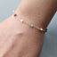 Bracelet with colorful beads on a wrist against a neutral background