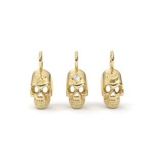 Gold skull-shaped earrings on a white background