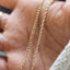 Product picture of a twisted rope chain in solid gold. This style is easy to style and looks good with any charms. Showing clasp.