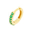 A pair of gold emerald pave huggie earrings.