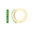A pair of gold emerald pave huggie earrings.