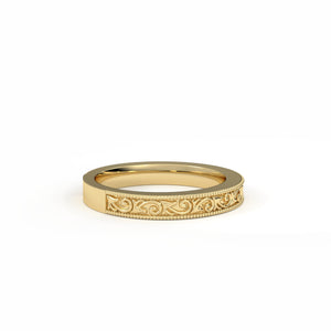 Gold ring with intricate design on a white background