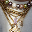 Close-up of a gold bracelet with charms on a plain background