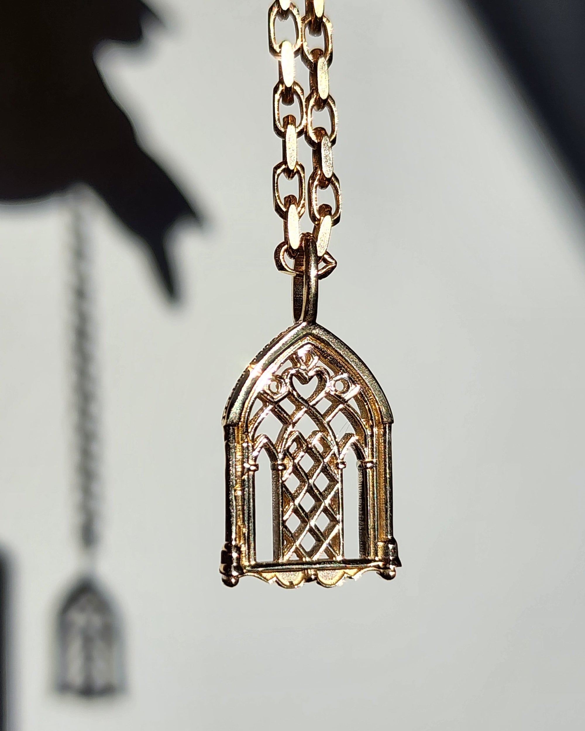 Gold necklace with a decorative pendant on a light background