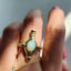 Gold ring with a colorful gemstone on a white background