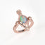 Rose gold ring with a colorful opal stone on a white background