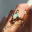 Gold ring with a colorful gemstone on a white background