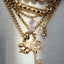 Close-up of a gold bracelet with charms on a plain background