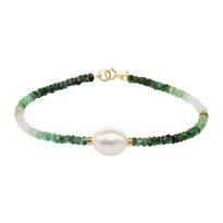 A faceted ombre beaded necklace with a large oval pearl in the center with two accent beads and round clasp. 