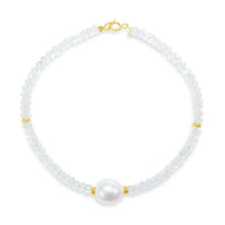 A faceted ombre beaded necklace with a large oval pearl in the center with two accent beads and round clasp. 