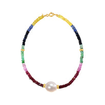 A faceted ombre beaded necklace with a large oval pearl in the center with two accent beads and round clasp. 