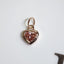 Heart-shaped pink gemstone pendant on a white background