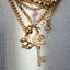 Close-up of a gold bracelet with charms on a plain background