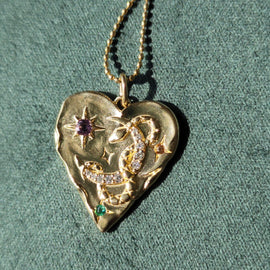Gold necklaces with various pendants on a textured surface