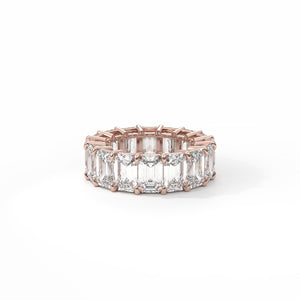 Rose gold ring with emerald-cut diamonds on a white background