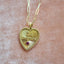 A solid gold heart pendant with beaded border. Old English Font " Toi Toujours" and a diamond in the center. Over all a vintage feeling.