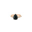 A vintage ring featuring black diamond in a pear shape, the diamond set with five prongs and has a diamond pave band on rose gold. 