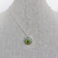 A silver pendant with hand painted green eye set in a round silver bezel setting. Pendant comes on a chain with a lobster clasp. 
