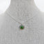 A silver pendant with hand painted green eye set in a round silver bezel setting. Pendant comes on a chain with a lobster clasp. 