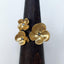 A flower ring with three flowers, each flower has four pedals and a center diamond. 