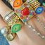 A green evil eye mosaic ring shown with other similar styled rings
