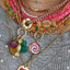 A hand carved gemstone gummy bear pendant offering four colors. three dimensional. 
