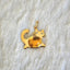 A yellow gold cat pendant with orange fire opal oval cabochon set at the belly. The cat has two diamond eyes and gold whisker and tail. 