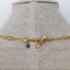 A long necklace with unique bone link chains. One of the links is a skull dagger the ends has a toggle clasp. 